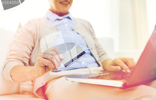 Image of senior woman with laptop and credit card at home