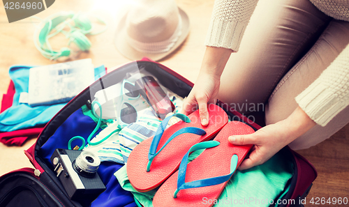 Image of close up of woman packing travel bag for vacation