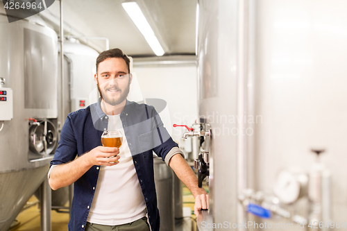 Image of man drinking and testing craft beer at brewery