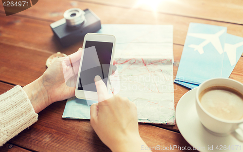 Image of close up of traveler hands with smartphone and map