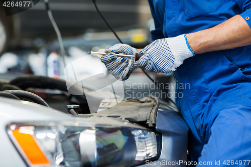 Image of mechanic man with wrench repairing car at workshop