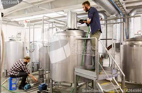 Image of men working at craft beer brewery kettles