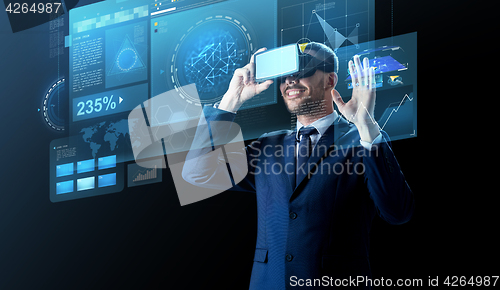 Image of businessman in virtual reality headset over black