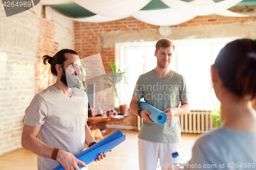 Image of group of people with mats at yoga studio or gym