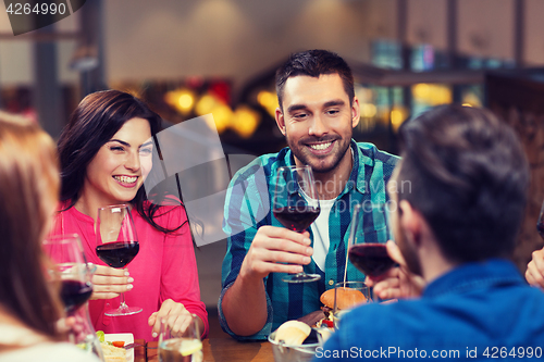 Image of friends dining and drinking wine at restaurant