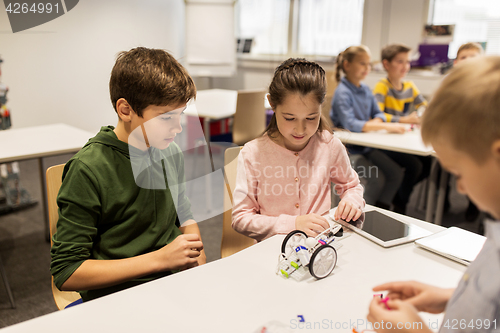 Image of happy children building robots at robotics school