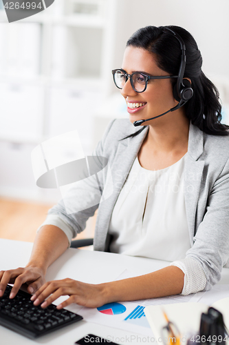 Image of businesswoman with headset and keyboard at office