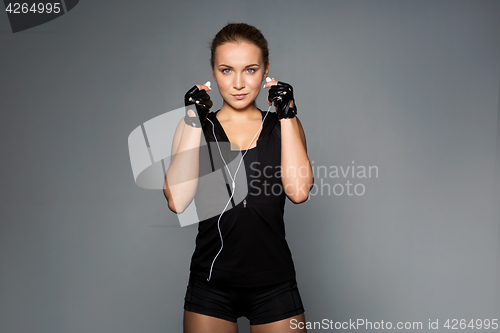 Image of woman with earphones listening to music in gym