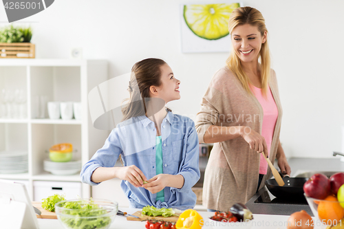 Image of happy family cooking salad at home kitchen