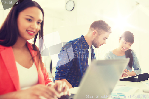 Image of creative team with tablet pc and papers at office
