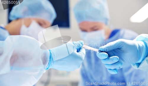 Image of close up of hands with scalpel at operation