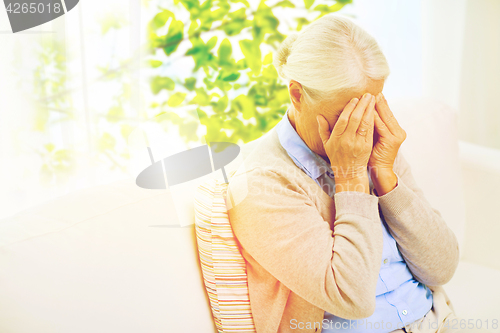 Image of senior woman suffering from headache or grief