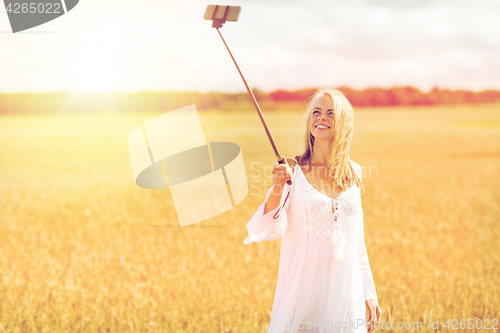 Image of happy young woman taking selfie by smartphone