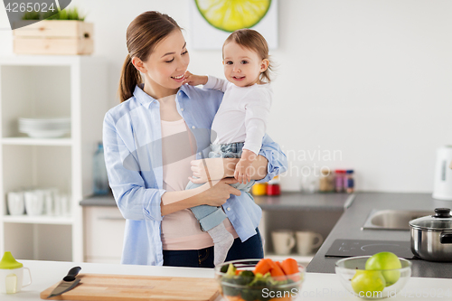 Image of happy mother and little baby girl at home kitchen