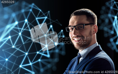 Image of smiling businessman in glasses over black