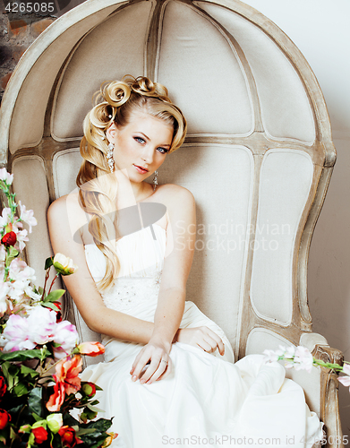 Image of beauty young blond woman bride alone in luxury vintage interior with a lot of flowers 