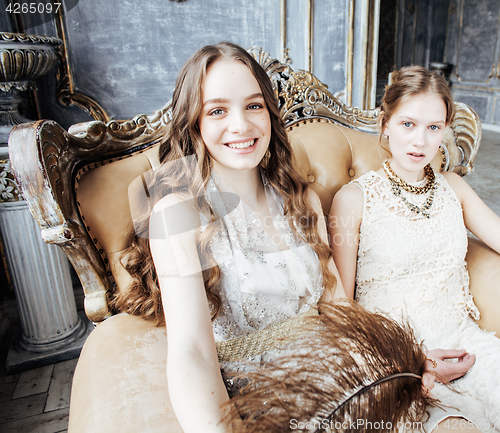 Image of two pretty twin sister blond curly hairstyle girl in luxury house interior together, rich young people concept 