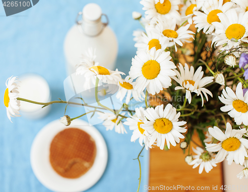 Image of Simply stylish wooden kitchen with bottle of milk and glass on table, summer flowers camomile, healthy foog moring concept