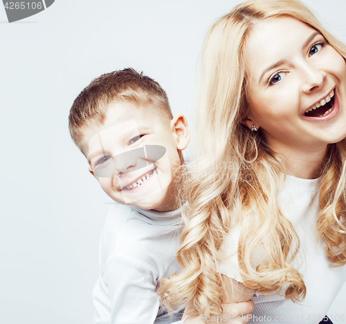 Image of young modern blond curly mother with cute son together happy smiling family posing cheerful on white background, lifestyle people concept, sister and brother friends 