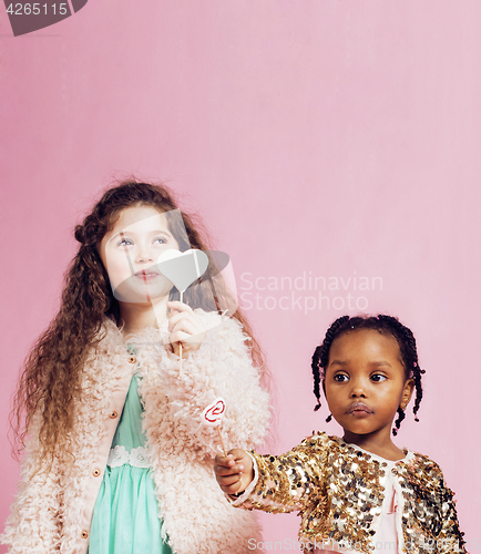 Image of lifestyle people concept: diverse nation children playing together, caucasian boy with african little girl holding candy happy smiling 