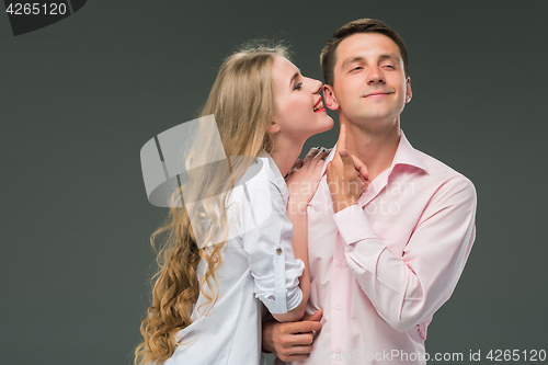 Image of Portrait of a young couple standing against gray background