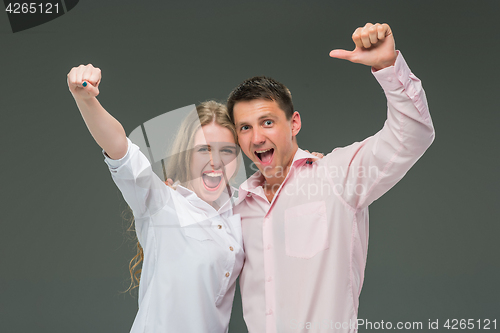 Image of Portrait of a young couple standing against gray background