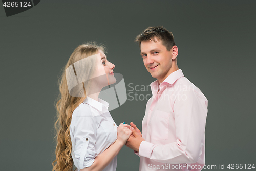 Image of Portrait of a young couple standing against gray background