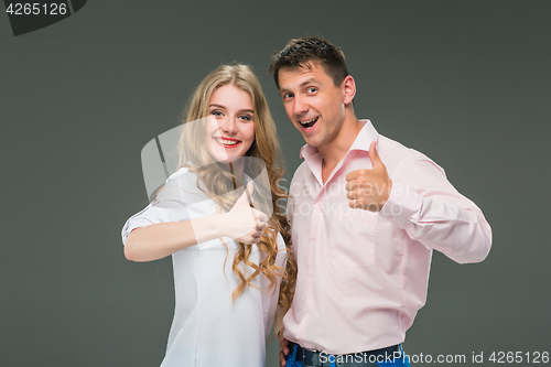 Image of Portrait of a young couple standing against gray background