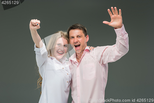 Image of Portrait of a young couple standing against gray background