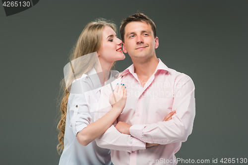 Image of Portrait of a young couple standing against gray background