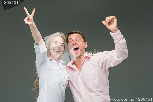 Image of Portrait of a young couple standing against gray background