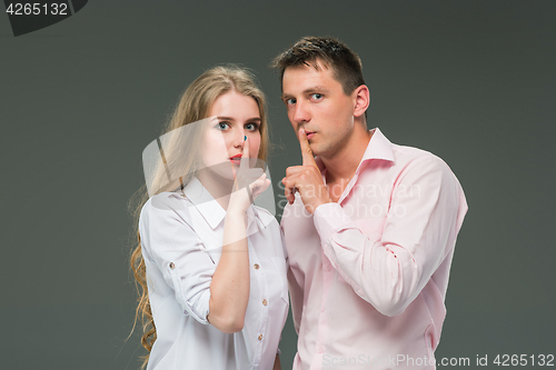 Image of Portrait of a young couple standing against gray background