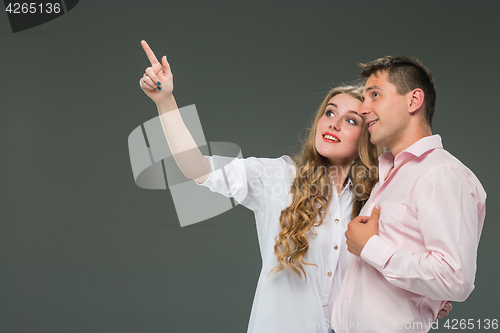 Image of Portrait of a young couple standing against gray background