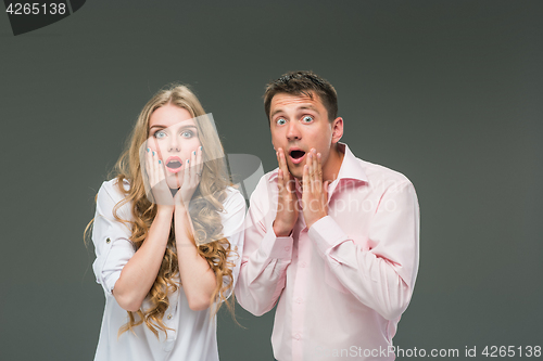 Image of Portrait of a young couple standing against gray background