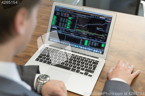 Image of Young businessman working with laptop, man\'s hands on notebook computer.