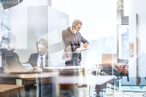 Image of Businessman talking on a mobile phone on corporate office.