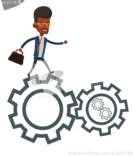 Image of Business man running on cogwheels.