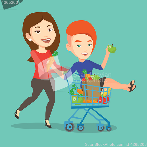 Image of Couple of friends riding by shopping trolley.