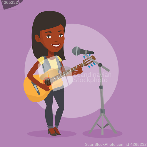 Image of Woman singing in microphone and playing guitar.