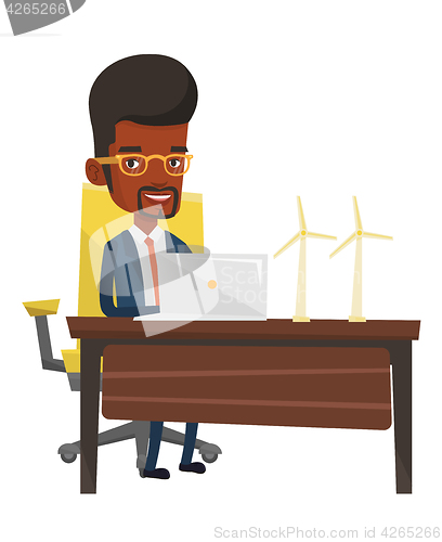 Image of Man working with model wind turbines on the table.