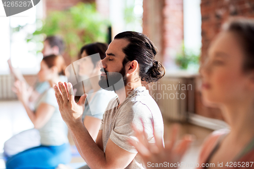 Image of group of people meditating at yoga studio