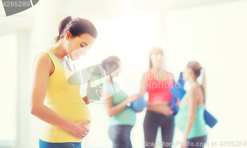 Image of happy pregnant woman with water bottle in gym