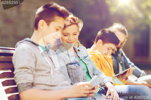 Image of happy teenage friends with tablet pc outdoors