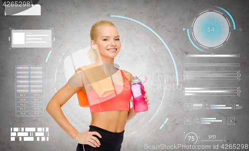 Image of smiling sporty woman with water bottle and towel