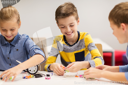 Image of happy children building robots at robotics school