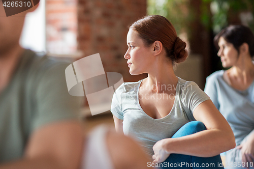 Image of woman with group of people doing yoga at studio