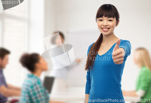 Image of happy smiling young woman showing thumbs up