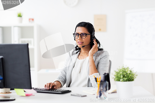 Image of businesswoman with headset and computer at office