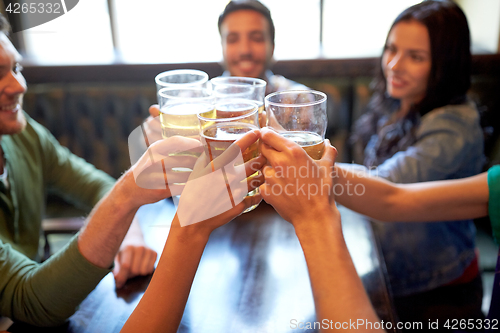 Image of happy friends drinking beer at bar or pub