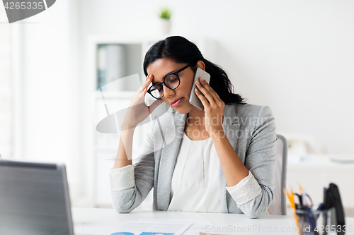 Image of stressed businesswoman with smartphone at office